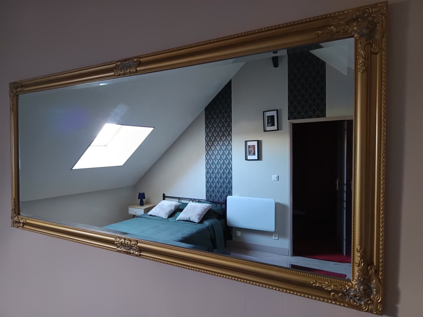 Miroir doré reflétant la chambre